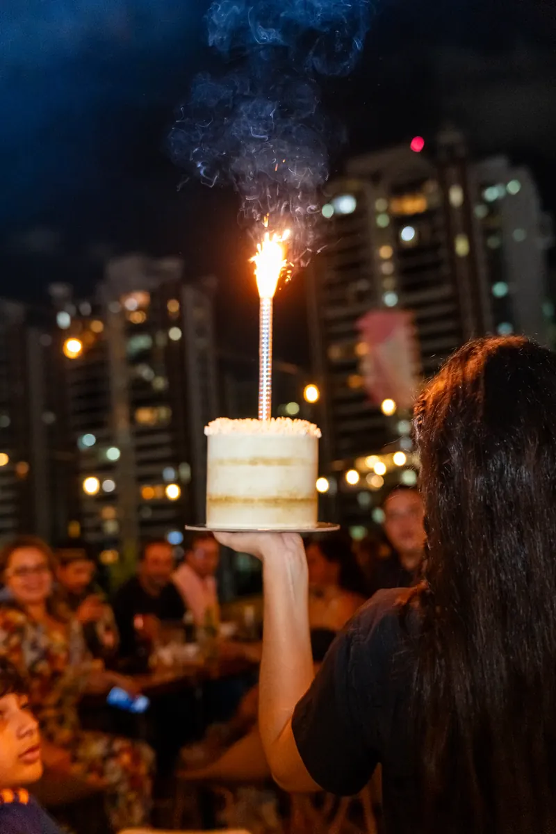 Birthday cake with a sparkler and the city at night at Terrat