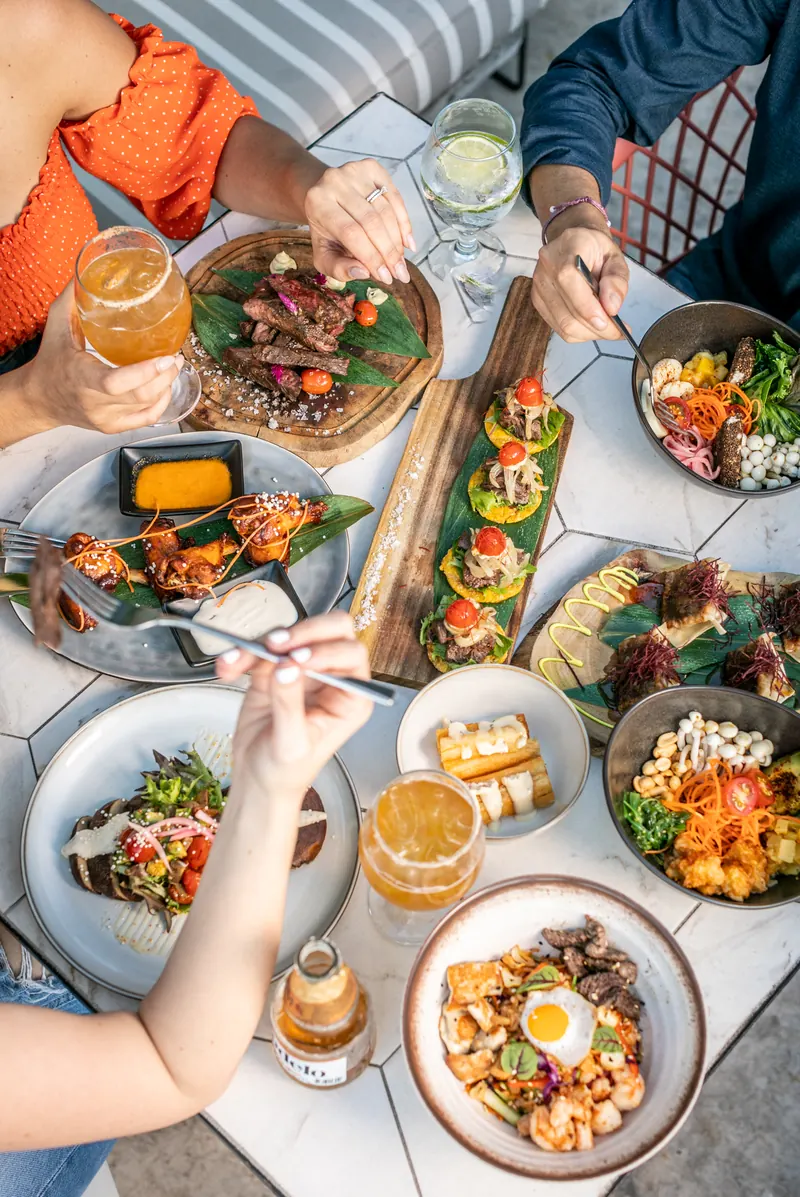 Table full of sharing plates and cocktails at Terrat Rooftop