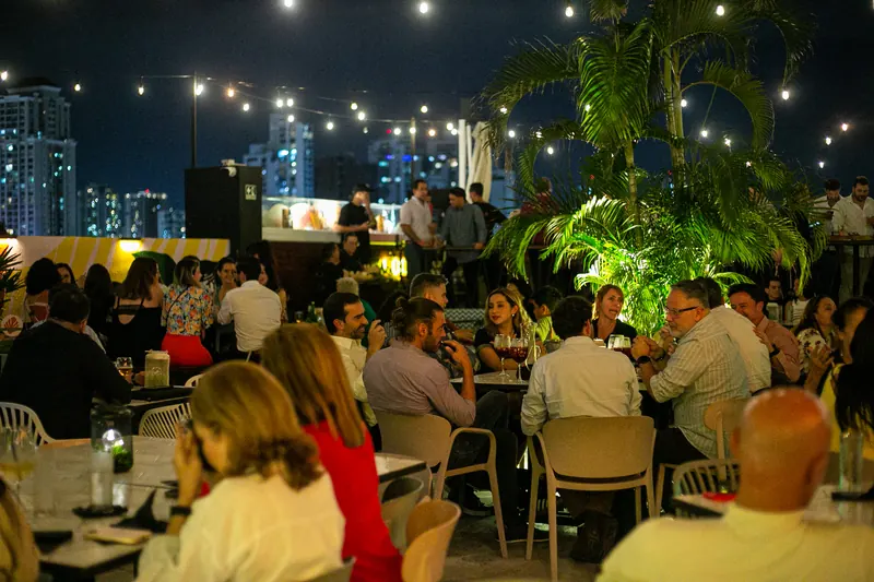 The Terrat terrace full at night with the San Francisco skyline lit up